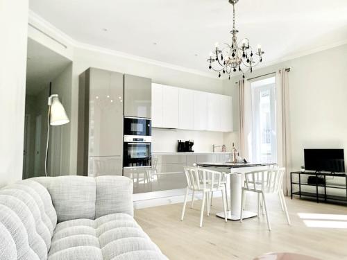 un salon blanc avec un canapé et une table dans l'établissement Luxuriously furnished bright newly renovated oasis, à Nice