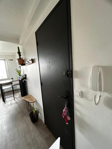 une porte noire dans une chambre avec téléphone dans l'établissement Zen, à Caen