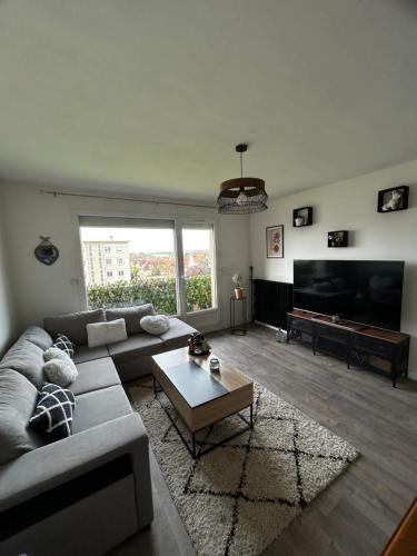 un salon avec un canapé et une table dans l'établissement Zen, à Caen