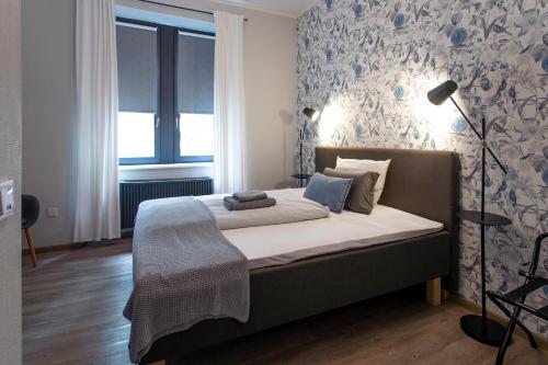 a bedroom with a bed with a blue and white wallpaper at Schlosshotel Braunfels & Himmelreich in Braunfels