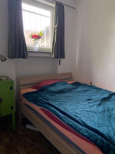 a bedroom with a bed with a blue blanket on it at Zentral gelegenes Zimmer mit Bad in Bietigheim-Bissingen
