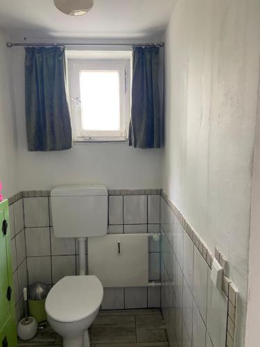 a bathroom with a toilet and a window at Zentral gelegenes Zimmer mit Bad in Bietigheim-Bissingen