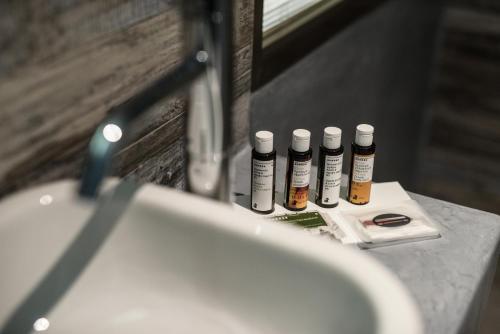 a bathroom sink with four bottles of hair products at Alika Resort in Álika