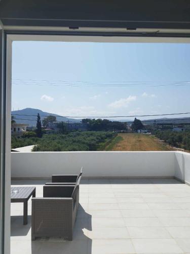 a room with a large window with a table and chairs at SunSea Studios close to the beach in Kato Gouves