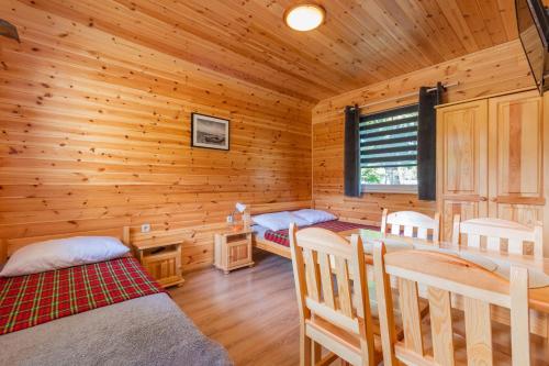 a log cabin with two beds and a desk at Domek 5 osobowy in Stegna