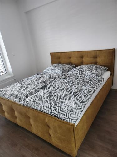 uma cama num quarto com piso em madeira em Apartmán Topoľčany em Topoľčany