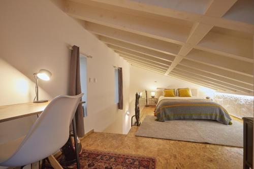 ein Schlafzimmer mit einem Bett, einem Tisch und einem Schreibtisch in der Unterkunft Maison214 in Vila Nova de Gaia