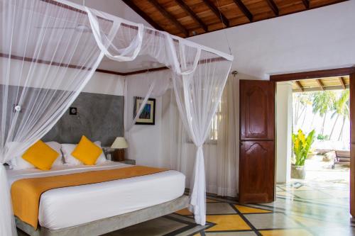 a bedroom with a bed with a canopy at The Saffron House in Dickwella