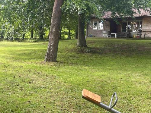 a baseball bat laying on the grass in front of a house at Lönnekullen, enkel sommarstuga mitt i skogen på Österlen med dusch ute in Gärsnäs