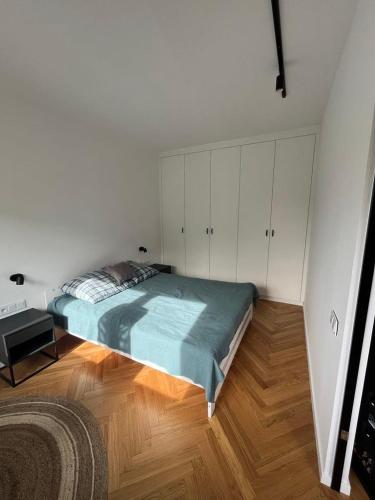 - une chambre avec un grand lit et des placards blancs dans l'établissement Joli Apartment, à Varsovie