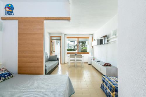a bedroom with a bed and a living room at Apartamentos Arcos II Casa Azahar in Alcossebre