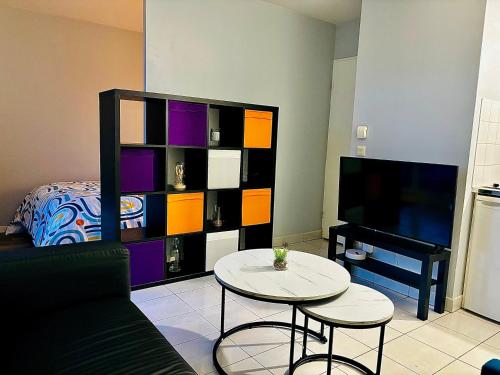 un salon avec un canapé, une table et une télévision dans l'établissement Appartement Cosy proche Paris La Défense, à Sartrouville