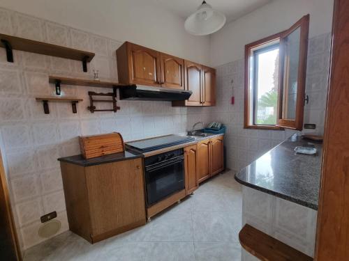 a kitchen with wooden cabinets and a stove top oven at CASA VIANNA in Magliano