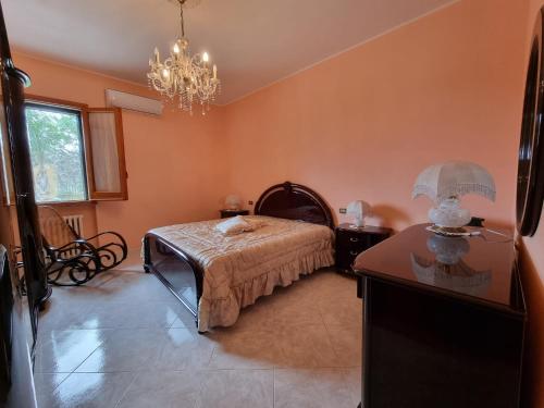 una camera da letto con un letto e un lampadario di CASA VIANNA a Magliano