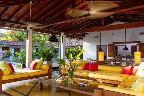 a living room with yellow couches and a table at The Saffron House in Dickwella