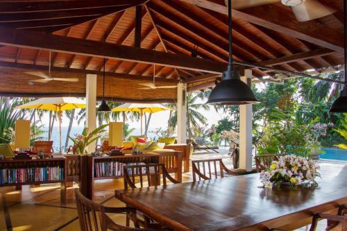 a dining room with a wooden table and chairs at The Saffron House in Dickwella