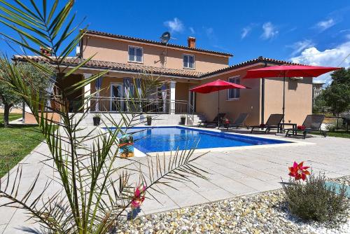 a villa with a swimming pool in front of a house at Ferienhaus mit Privatpool für 8 Personen ca 130 qm in Divšići, Istrien Südküste von Istrien in Divšići
