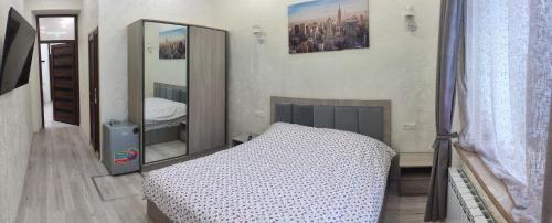 1 dormitorio con cama y espejo en TARTU en Gyumri