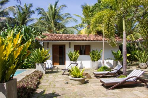 a villa with a swimming pool and palm trees at The Saffron House in Dickwella