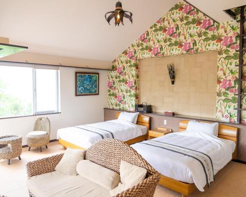 石垣島にあるアレーズド バレ ISHIGAKIのベッド2台とソファが備わるホテルルームです。