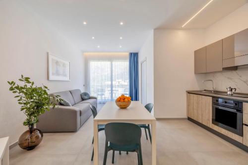 eine Küche und ein Wohnzimmer mit einem Tisch und einem Sofa in der Unterkunft Case Vacanza Loria in Castelluzzo