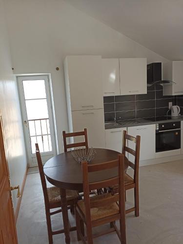 une cuisine avec une table et des chaises dans une pièce dans l'établissement La Grange, à Roquemaure