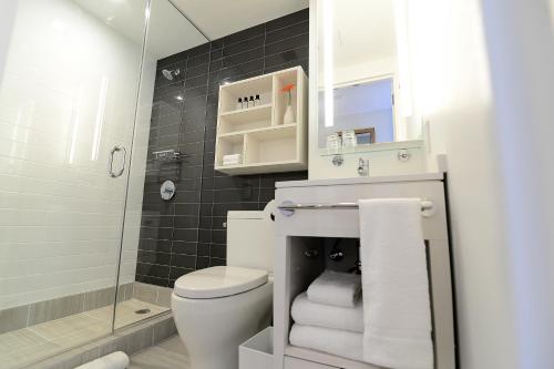 a bathroom with a toilet and a sink and a shower at Edge Hotel Washington Heights in New York