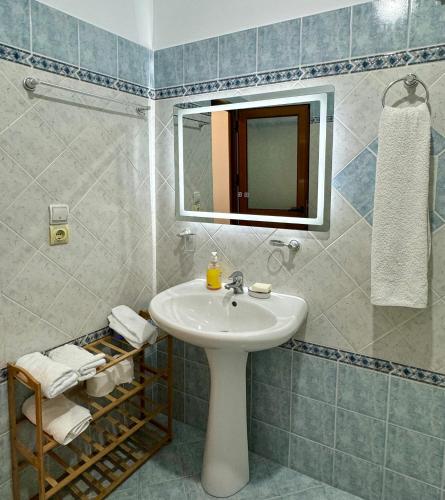 a bathroom with a sink and a mirror at SHEMO Apartments in Sarandë