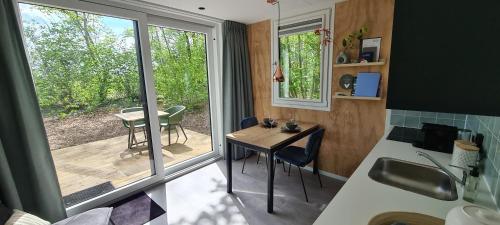 a tiny house with a small table and a balcony at Logies Prinsewyk De Knipe/Oranjewoud in Bovenknijpe