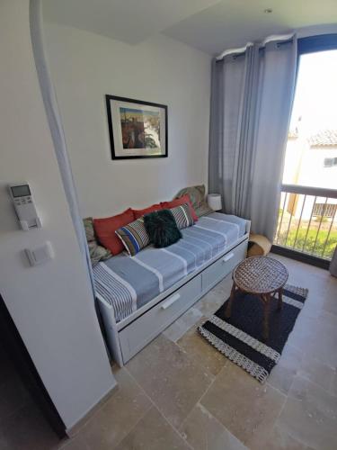 un canapé dans un salon avec une fenêtre dans l'établissement La Petite Perle, à Cogolin