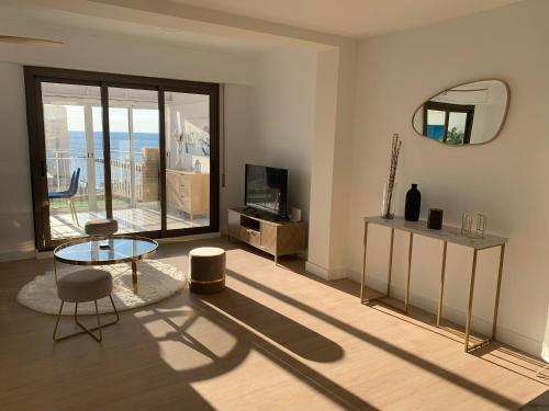 a living room with a table and a mirror at ARENA & MAR in El Campello