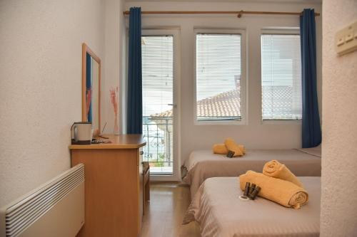 Zimmer mit 2 Betten, einem Schreibtisch und Fenstern in der Unterkunft Villa Marto Old Town Ohrid in Ohrid