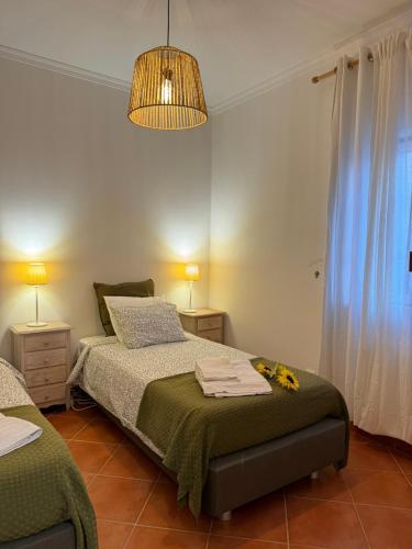 a bedroom with two beds and a chandelier at Casa de Praia em Almograve - Quarto trilho dos Pescadores in Odemira