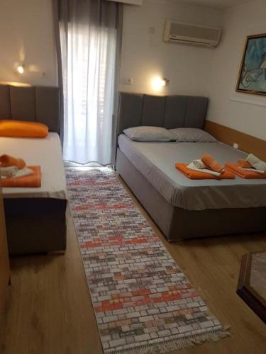 two beds in a room with a rug at Apartments Bonus in Budva