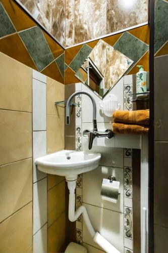 a bathroom with a sink and a mirror at Residence Art Guest House in Plovdiv