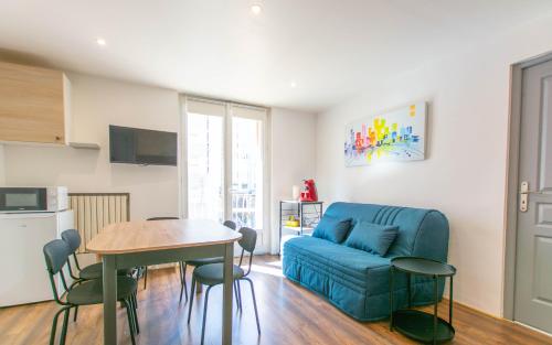 a living room with a blue couch and a table at Appartement T3 gare de Chambéry centre ville in Chambéry