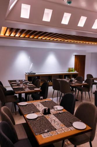 a dining room with tables and chairs and a stage at Hotel Beyond Blu,Port Blair in Port Blair