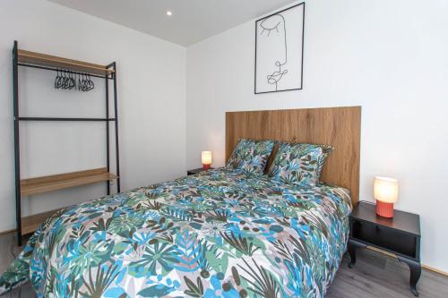 Appartement T3 gare de Chambéry centre ville في شامبيري: غرفة نوم مع سرير مع لحاف ملون