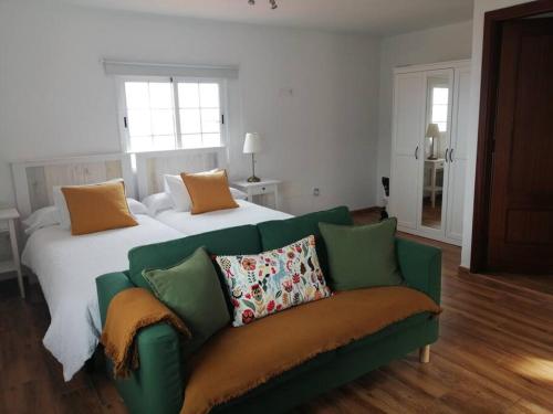 sala de estar con sofá verde y cama en Vivienda Vacacional Los Frailes 2, en Breña Baja