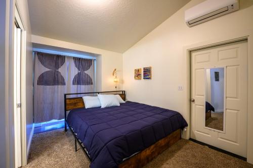 Blue House - private 2 bed, 2 bath home with garage في يوجين: غرفة نوم مع سرير مع لحاف أرجواني