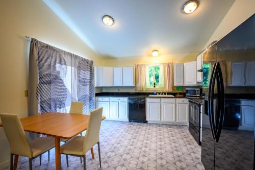 a kitchen with a wooden table and white cabinets at Blue House - private 2 bed, 2 bath home with garage in Eugene