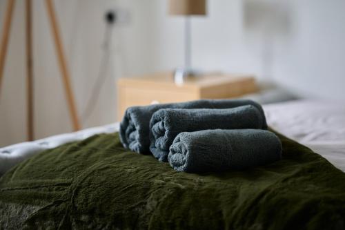 a group of towels sitting on top of a bed at Cherish Stays spacious & amazing 3 Bed House in Hayes & Heathrow in West Drayton
