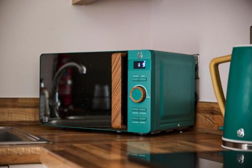a green toaster oven sitting on top of a counter at Cherish Stays spacious & amazing 3 Bed House in Hayes & Heathrow in West Drayton