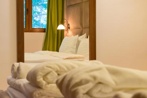 a bed in a hotel room with a mirror at Hotel & Spa Tino Sveti Stefan in Ohrid