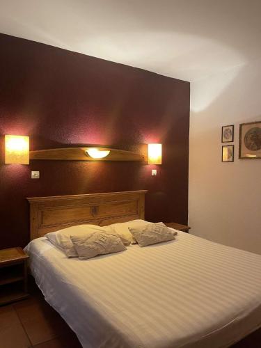a bedroom with a large bed with two pillows at Le Château du Landsberg in Barr