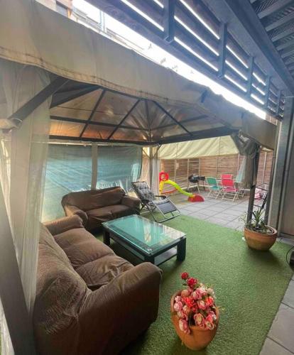 - un salon avec un canapé et une table dans une tente dans l'établissement Appartement Aubervilliers, à Aubervilliers