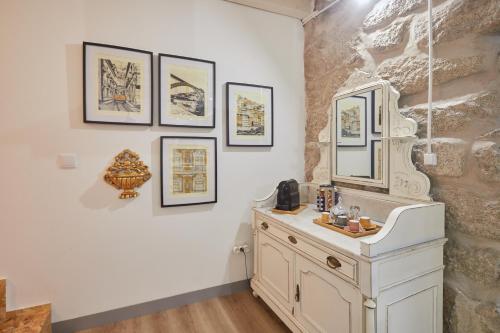 ein Badezimmer mit einem weißen Waschbecken und Bildern an der Wand in der Unterkunft Maison214 in Vila Nova de Gaia