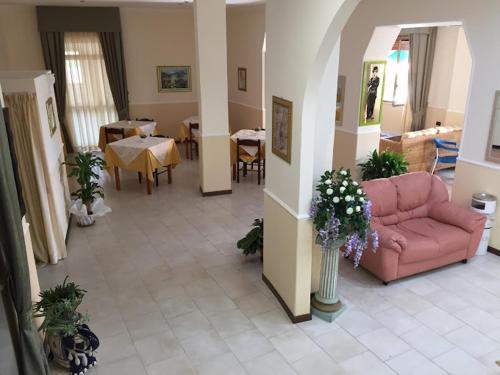 卡波裡祖托的住宿－Albergo Bed and breakfast FLORIDA，客厅配有粉红色的沙发和桌子