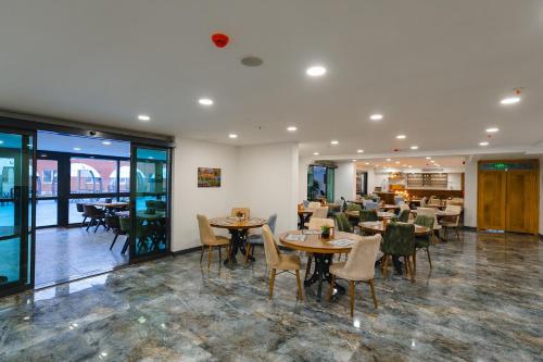 una sala da pranzo con tavoli e sedie e un ristorante di Berlin Suite Hotel Trabzon a Trabzon