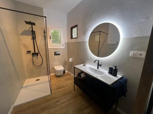 bagno con lavandino, doccia e specchio di Casa Esmeralda a Vejer de la Frontera